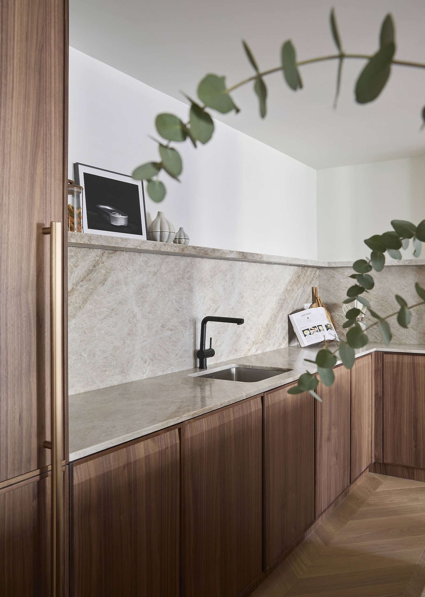 Cocina de madera con encimera de piedra beige y grifo negro moderno