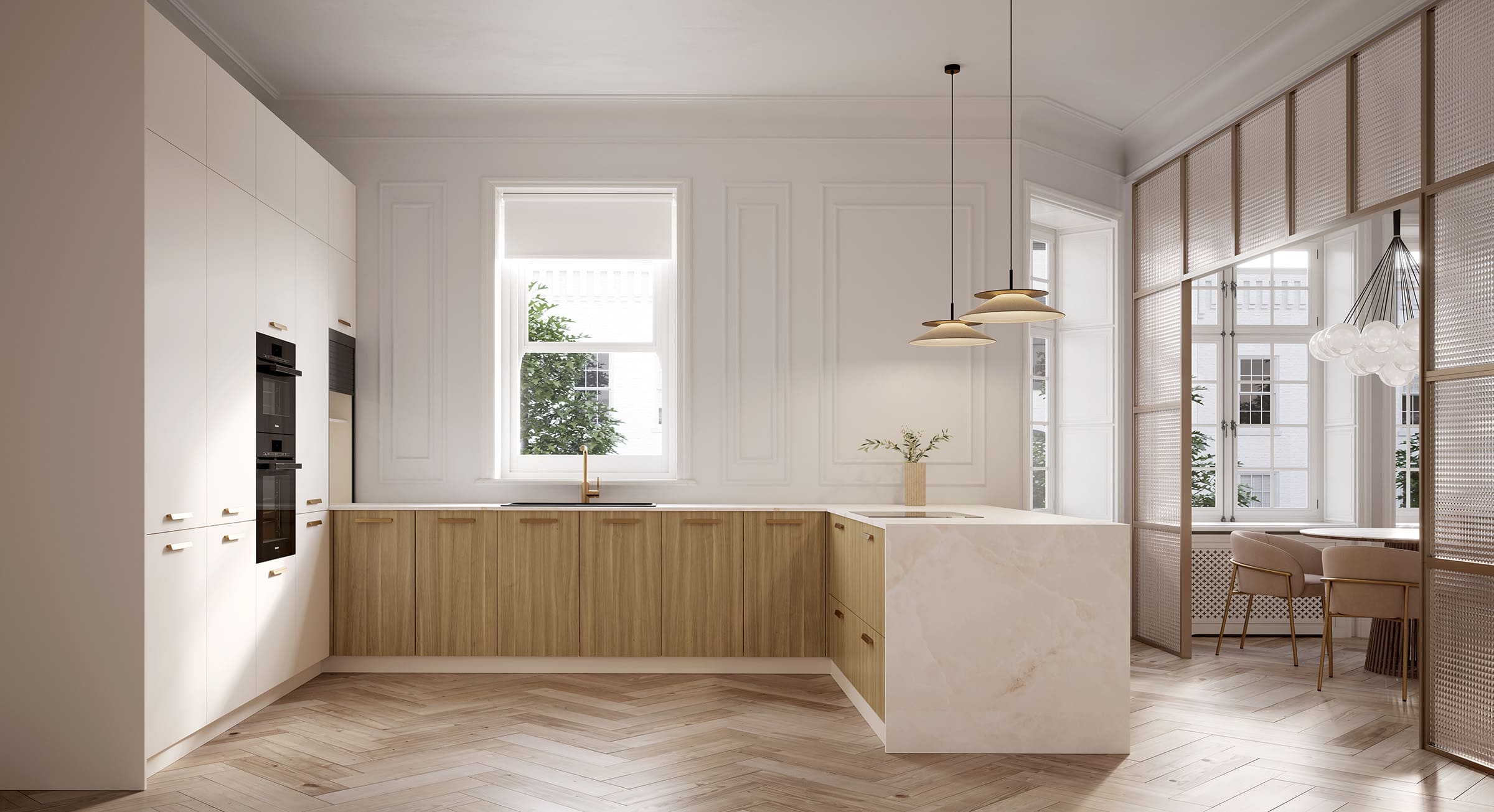 Cocina en L con muebles blancos y de madera clara, isla de mármol y luminarias colgantes doradas.