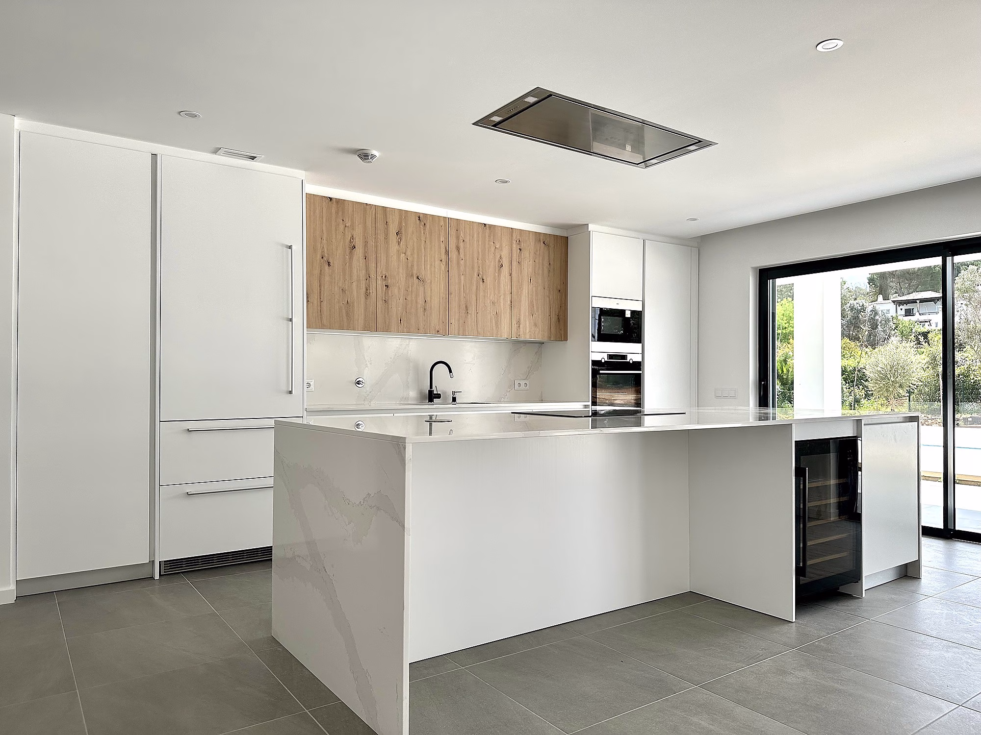 casa-design-portugal---cocina-blanca-con-detalles-de-madera--tiradores-de-metal--isla-y-encimera-de-marmol-_2.-pim2-2000_q